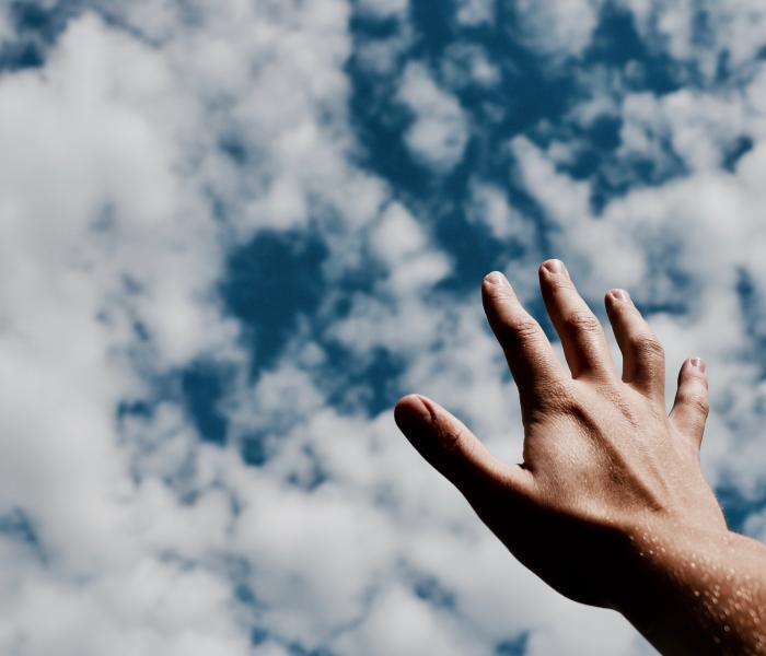 One hand reaching for clouds