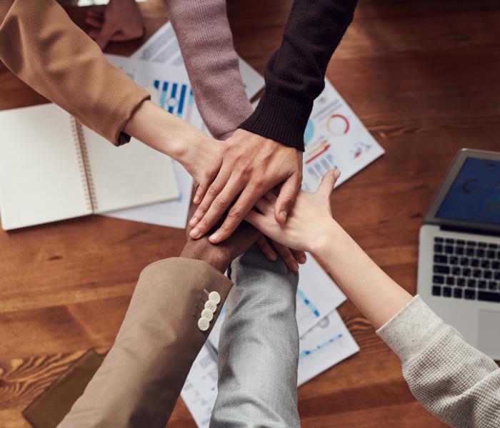Team handshake with five hands