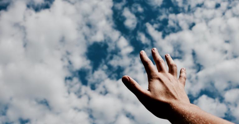 One hand reaching for clouds