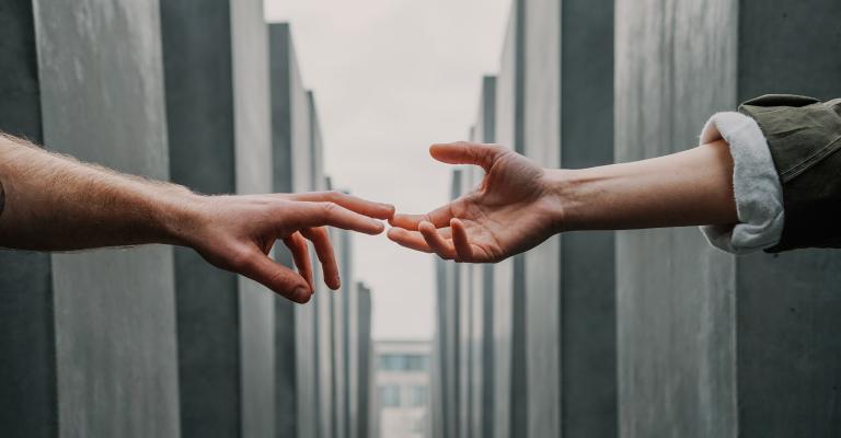 two hands reaching for each other