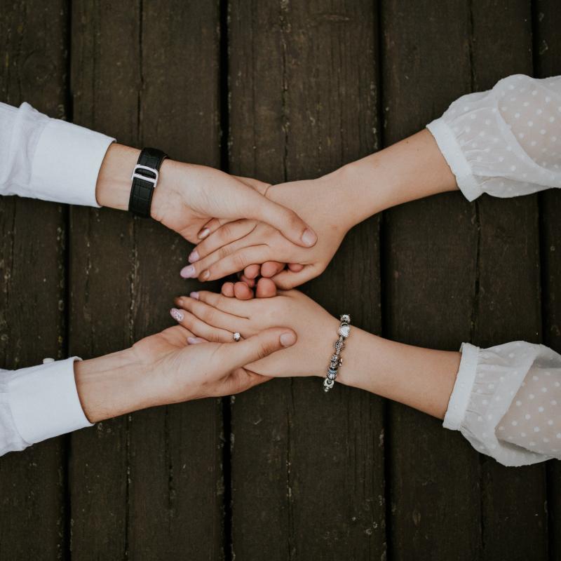 Two pair of hands holding each other