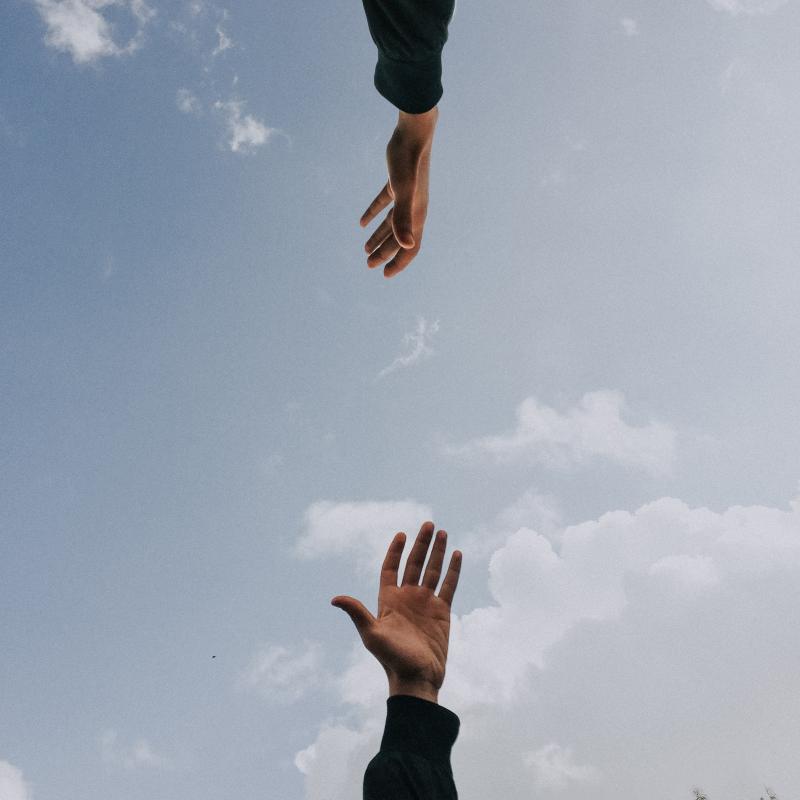two hands reaching for each other 