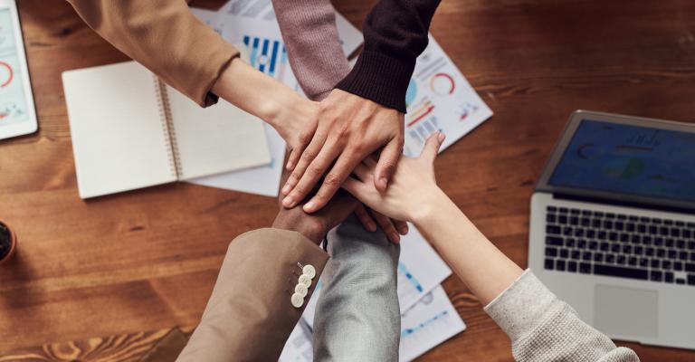 Team handshake with five hands