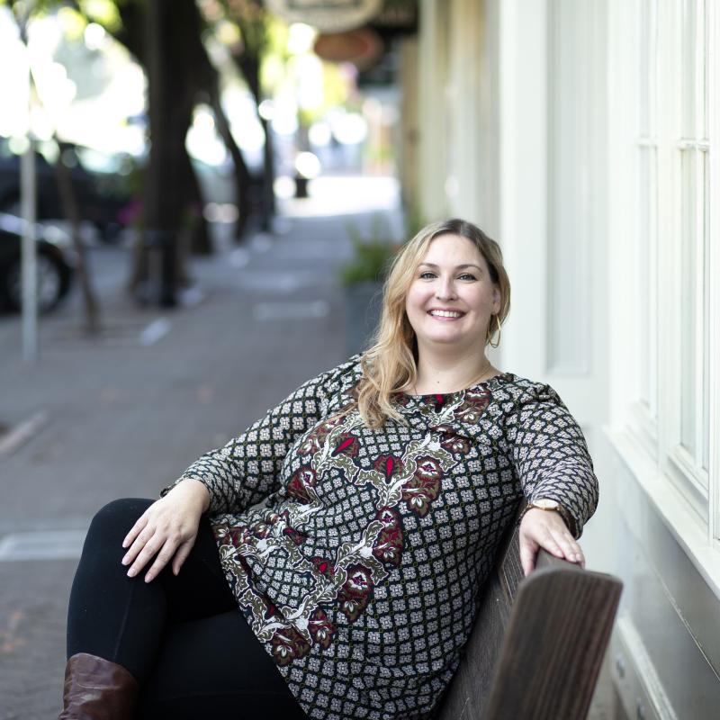 Christy Livingston sitting on a bench smiling into the camera
